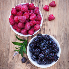 Bowls overflowing with summer berries like raspberries and blackberries.
