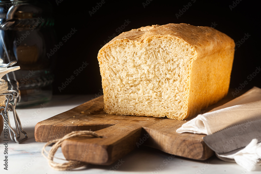 Wall mural Fresh homemade Toast bread on the kitchen table, dark background.