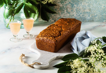 summer sweet loaf cake on a table with flowers and a drink in glasses. dessert for brunch or morning breakfast