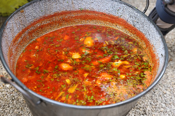 borsch in a huge cauldron - traditional beetroot soup on the picnic