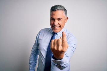 Middle age handsome grey-haired business man wearing elegant shirt and tie Beckoning come here gesture with hand inviting welcoming happy and smiling