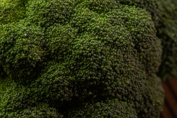 Broccoli isolated. On a wooden background. Top view. Free space for your text. Close up green plant ingredient, raw green vegetables, vegetable front view. Concept of vegan food uncooked.