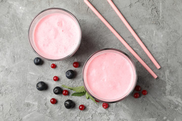 Delicious berry milkshakes on gray table. Summer drink