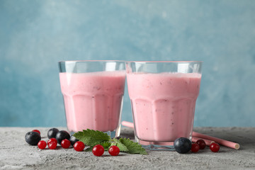 Delicious berry milkshakes on gray table. Summer drink