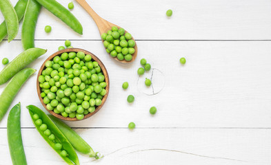 Fresh green peas with pod in bowl and spoon on wooden table, healthy green vegetable or legume ( pisum sativum ) - obrazy, fototapety, plakaty