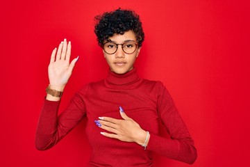 Young beautiful african american afro woman wearing turtleneck sweater and glasses Swearing with...