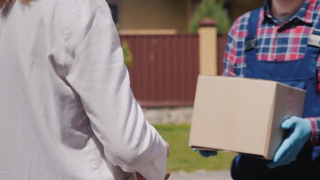 Courier brings parcel to the recipient's house, woman picks it up
