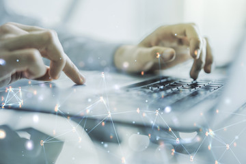 Double exposure of technology hologram and hands typing on laptop on background. Research and...