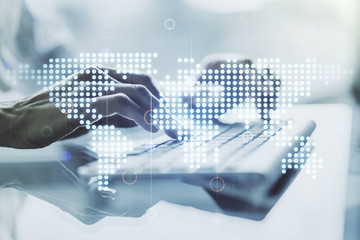 Abstract creative digital world map and hands typing on laptop on background, globalization concept. Multiexposure