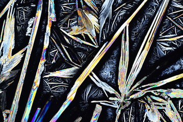 Colorful micro crystals in polarized light. Photo through a microscope.