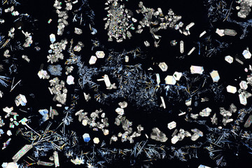 Colorful micro crystals in polarized light. Photo through a microscope.