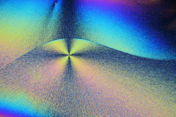Colorful micro crystals in polarized light. Photo through a microscope.