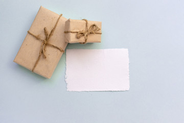 Gift box with kraft paper and a sheet of paper for text on a light blue background. Flat lay for father's day concept.