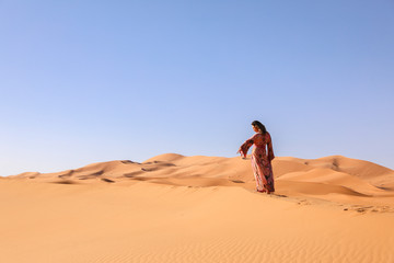 A girl in a beautiful Moroccan dress. Merzouga Morocco.