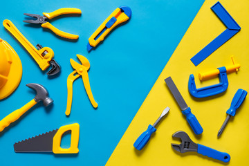 Toys background. Top view of toy tools on blue yellow background