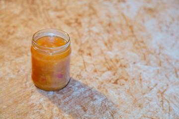 Appetizing homemade sweet sugar jam with slices of fresh peaches