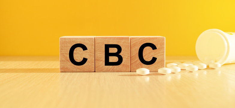 inscription cancer on wooden cubes on a yellow background with pills