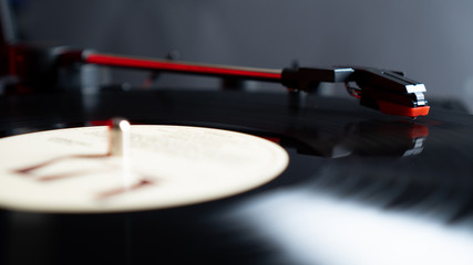 Close up vinyl needle stylus on rotating black vinyl plate or disk with copy space. Turntable vinyl record player.