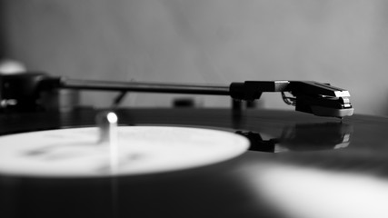 Black and white vinyl needle stylus on rotating black vinyl disk with copy space. Turntable vinyl...