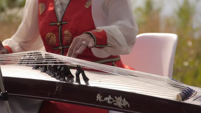 A woman in a national costume plays the Buryat national string instrument