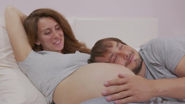 Happy couple together expecting a baby. Husband hugs Belly Of His Pregnant Wife.