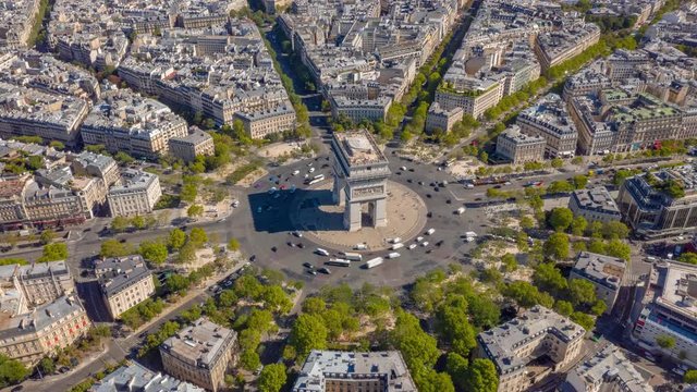 flight over paris city sunny day famous triumph arch traffic circle streets aerial timelapse panorama 4k france