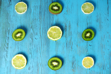 slices of yellow and green fruits laid out on a wooden blue background