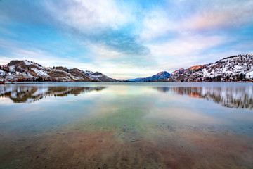 Fototapeta na wymiar The water on Skaha lake reflects the beautiful winter colors onto it in Okanagan Falls bc.