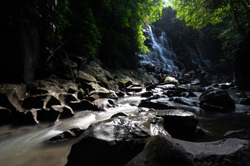 Obraz premium sun shines through the jungle at waterfall in bali indonesia