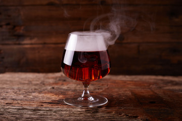Glass of whiskey on wooden table