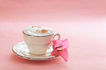 Café espumoso con buganvilia en fondo rosa