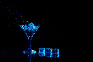 Martini cocktail drink splash with ice cubes in neon iridescent . Minimal night party life concept.