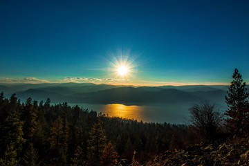 The sun falls on the mountain range overlooking okanagan lake