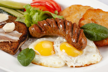 Potato pancakes with sausage, fried egg, toast, garlic and lard