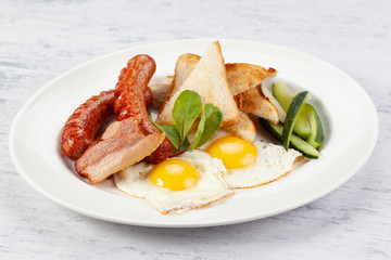 Sausages with fried eggs, bacon and toast