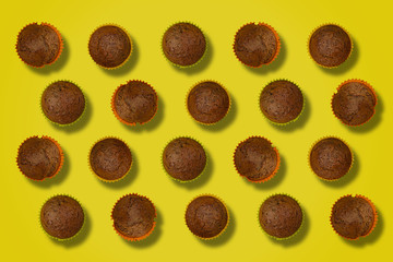pattern of freshly baked cupcakes on a yellow background 