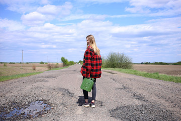 A young girl in a red plaid shirt with a canister in her hand turned around in the middle of a...