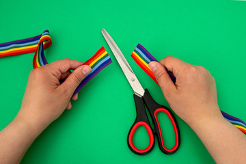 Prohibition of demonstrations and same-sex marriage. The LGBT rainbow ribbon tape is cut with scissors.