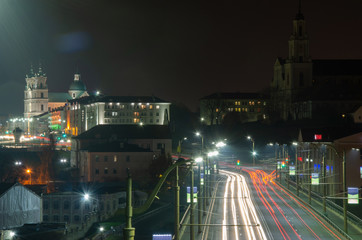 Grodno, Belarus, November 2, 2018: Night city. The light trails on the street. Slow shutter speed photo. A long bridge across the river leads to the big city. A busy expressway in the town center.