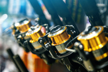 Fototapeta na wymiar fishing reels of different sizes on the counter in the fishing store. Shallow depth of field,Closeup of a fishing reel