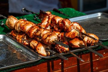 Slice pieces of meat on the grill. barbecue at the festival. Cheese and roasted veal on skewers.Cooking at the festival.