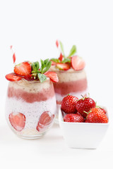 Glass of sweet delicious homemade layered smoothie dessert made from fruits and berries. delicious Strawberry banana milkshake, vegan raw food. Selective focus. Chia pudding with oatmeal