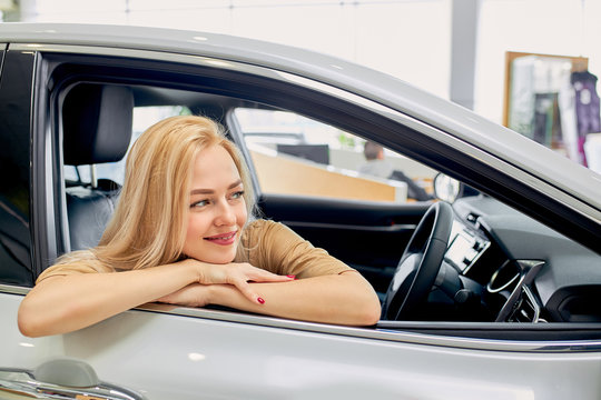 I Wish I Had Such A Car! Woman Dream, Want To Buy A Car, She Sits Inside Of Auto, Like It, Female Look Side. In Dealership