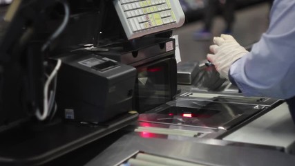 Close up shot of cashier scanning food at checkout counter. Buying meal in a supermarket Cashier in protective rubber gloves. Purchasing goods during lockdown