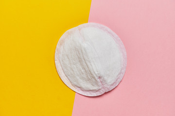 Women pad for bra on a yellow and pink background with a top view