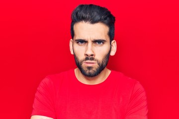 Young handsome man with beard wearing casual t-shirt skeptic and nervous, disapproving expression on face with crossed arms. negative person.