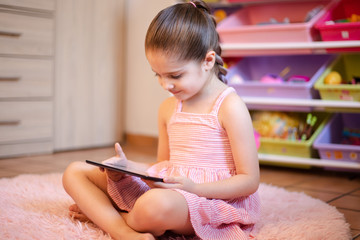 little girl reading a tablet