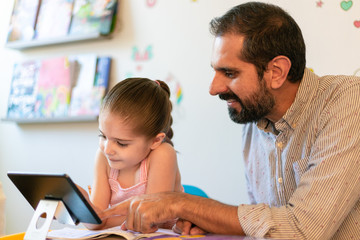 father and daughter using tablet