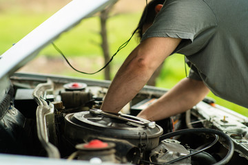 man makes car repair under the hood. street repair