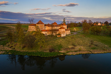 The beautiful medieval castle in the village of Svirzh Swirz in Western Ukraine in late calm evening, aerial view. Mighty fortress is popular tourist destination and place of summer opera festival